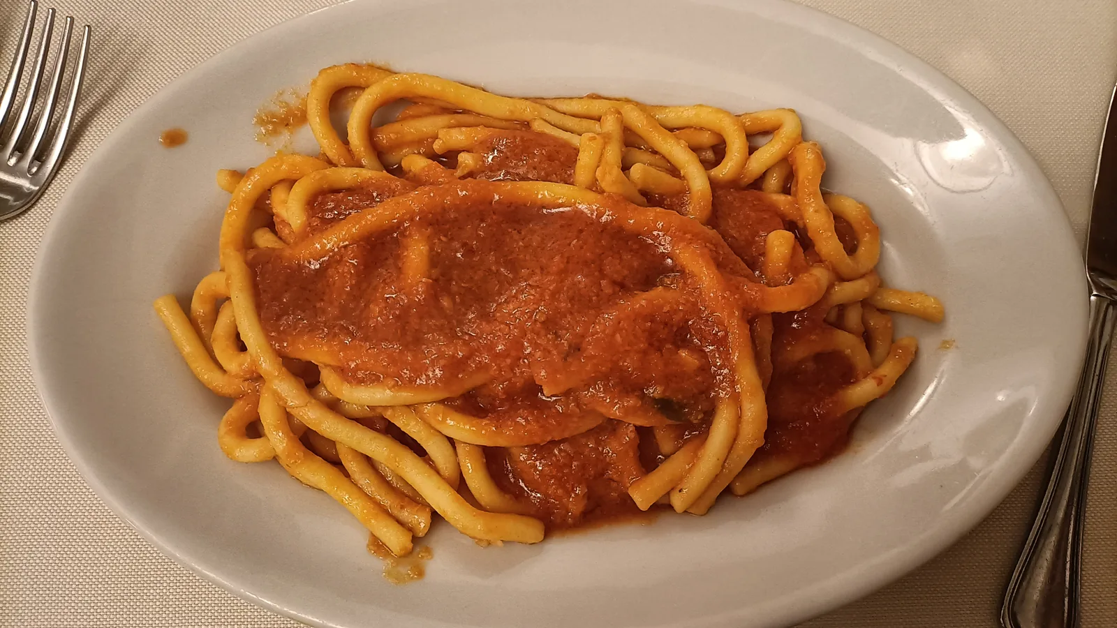 Plate of pici all'aglione, a traditional Tuscan pasta dish
