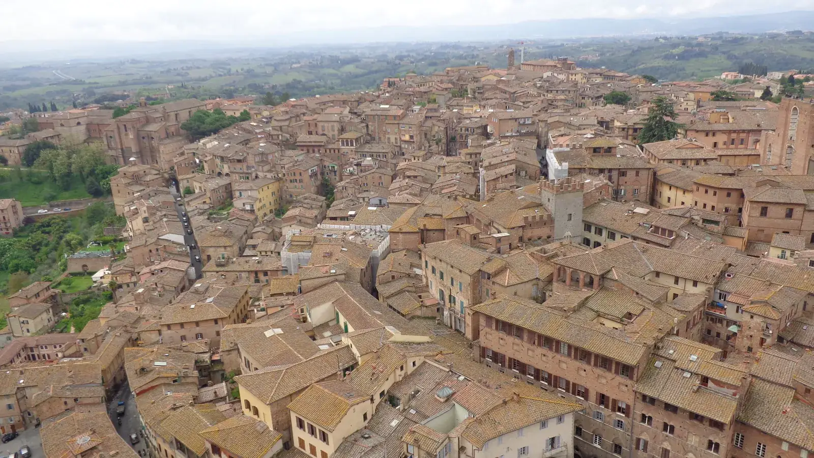 Terracotta rooftops in Siena with the Tuscan countryside beyond